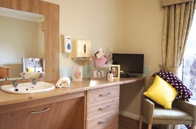 Cozy resident room with personal touches and a TV