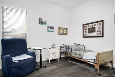 Comfortable private resident room with a bed and chair