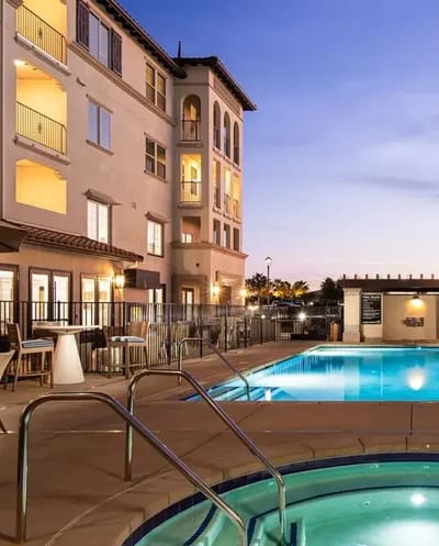 Outdoor pool area with lounge chairs and building