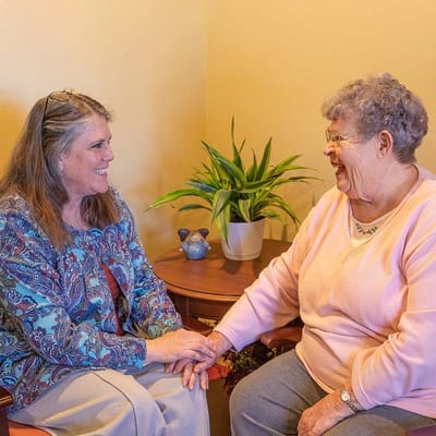 A caregiver and resident sharing a moment indoors