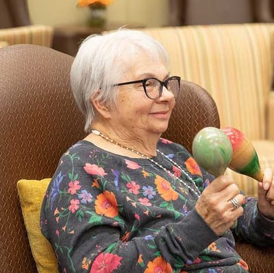 Senior resident playing with maracas in a common area