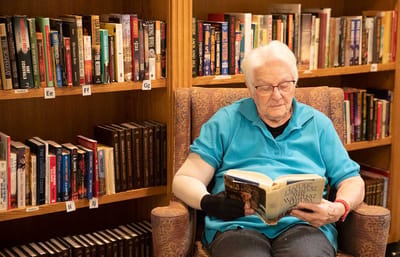 A resident reading in a library setting