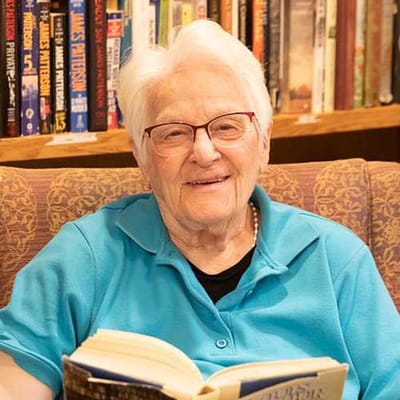 Elderly resident reading a book in a cozy chair