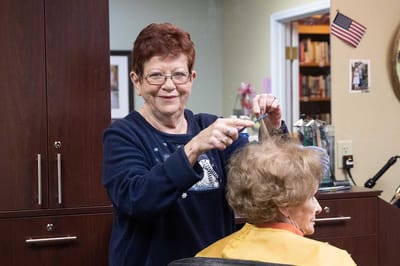 Stylist giving a haircut to a resident in a salon