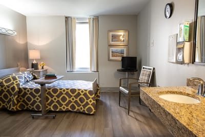 A private resident room with a cozy bed and desk