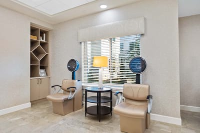 Hair salon area with leather chairs and lamp