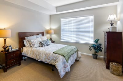 Well-decorated private resident room with a bed and lamps