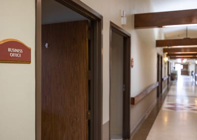A hallway with a sign for the business office