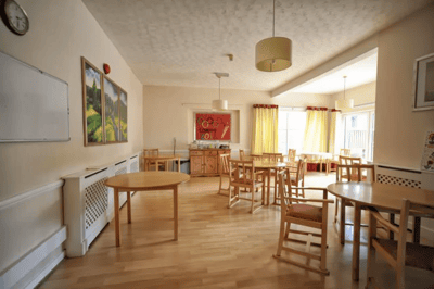 Bright common area with wooden tables and chairs