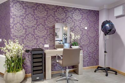 Beauty salon area with a hair dryer and mirror