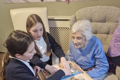 Residents engaging in a puzzle activity with visitors
