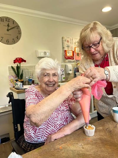 Residents participating in a cupcake decorating activity