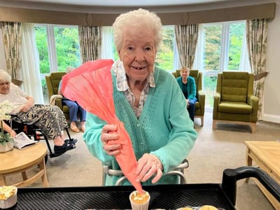 A resident decorating cupcakes in an activity room