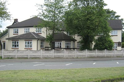 Wingates Residential Home, residential care in Bolton, UK — Residential building with trees and a white fence