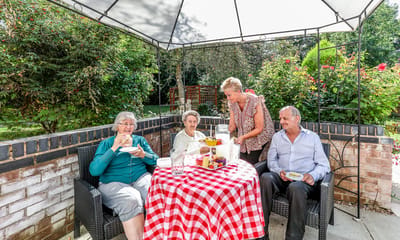 Residents enjoying food and conversation in an outdoor space
