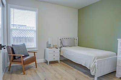 Modern private resident room with a bed and chair