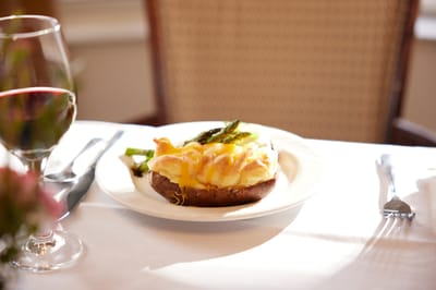 A plated meal with asparagus and cheese on a table setting