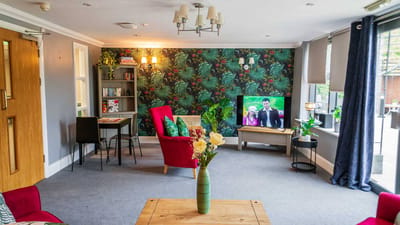 Bright common area with floral wallpaper and seating