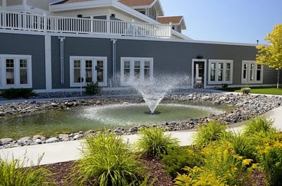 Outdoor fountain surrounded by landscaping at a senior living facility