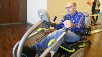 Resident exercising on a seated workout machine