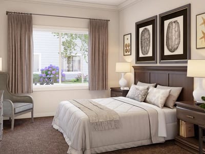 Well-furnished bedroom with natural light and flowers outside
