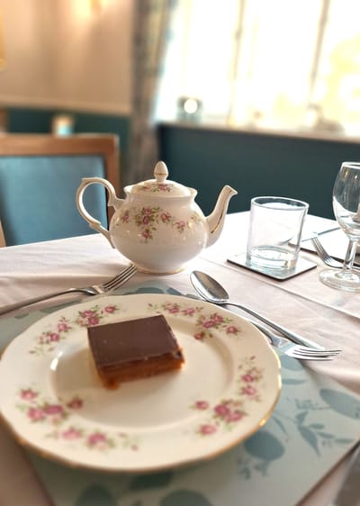 Tea service with a dessert served on a floral plate