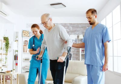 Staff assisting a resident in a bright living area