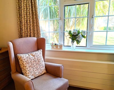 Cozy chair by a window with a floral arrangement
