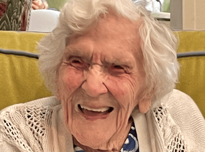 Smiling elderly woman sitting indoors