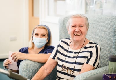 Resident and staff member smiling together