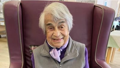Senior resident smiling in a chair
