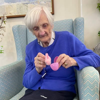 Senior resident engaging with a small toy