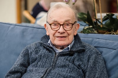 Senior resident smiling in a cozy indoor setting.
