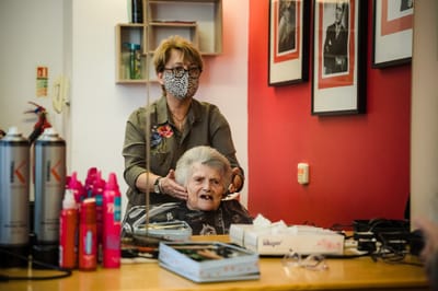 Hair salon scene with resident and staff member.