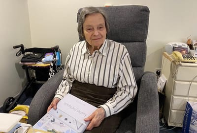 Resident sitting in a chair with a book.