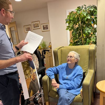 Staff interacting with a resident in a cozy setting.