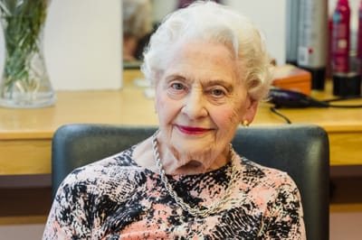 Elderly woman smiling at a hair salon