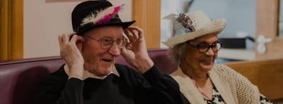 Residents wearing hats enjoying a social activity.