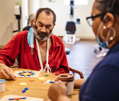 Resident and staff member engaging in an activity.