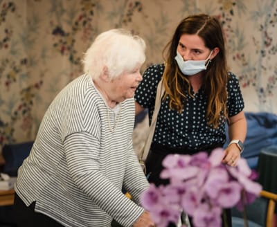 Resident and staff member interacting in a cozy interior