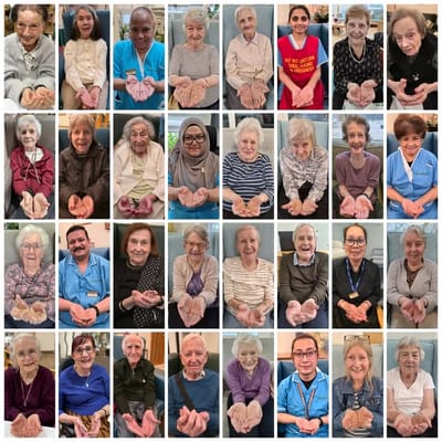 Residents and staff holding hands in a caring display.