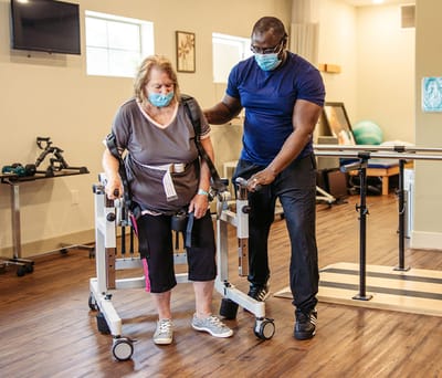 Staff assisting resident with rehabilitation
