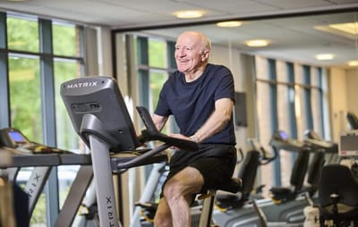 Senior man exercising on a bike in the gym