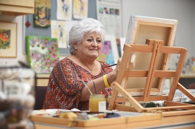 Resident painting in an activity room