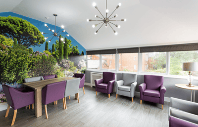 Bright common area with modern furniture and wall mural.
