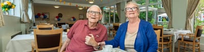Two residents enjoying time together in a common area.
