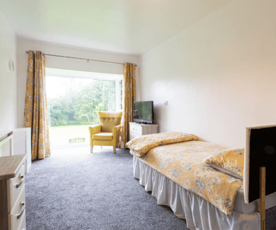 Cozy resident room with a view of greenery.