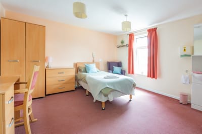 Bright resident bedroom with furniture and decor