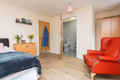 Cozy resident room with bed and armchair