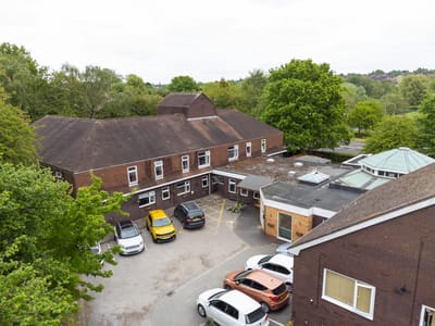 Aerial view of the facility with parking and green areas.